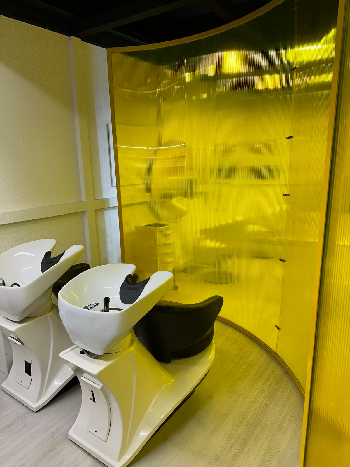 Área de lavatórios com painel amarelo assinatura